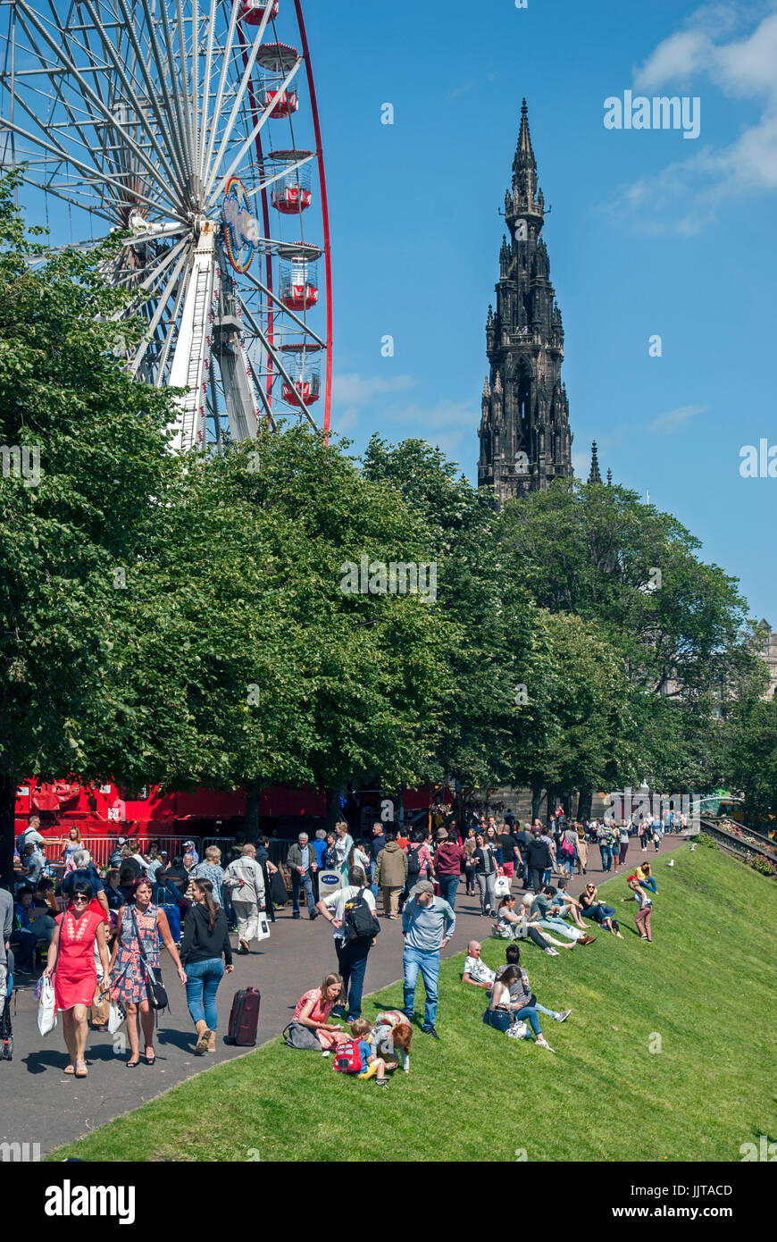 Einheimische und Touristen genießen die Sonne und die Sehenswürdigkeiten in Princes Street Gardens, Edinburgh, Schottland, Großbritannien. Stockfoto