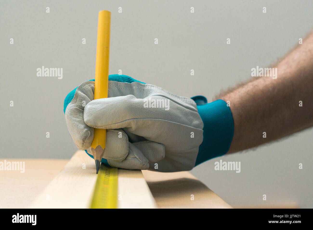 Schreiner Handwerker mit Bleistift die Planke auf die Holzarbeit Workshop Tabelle markieren Stockfoto