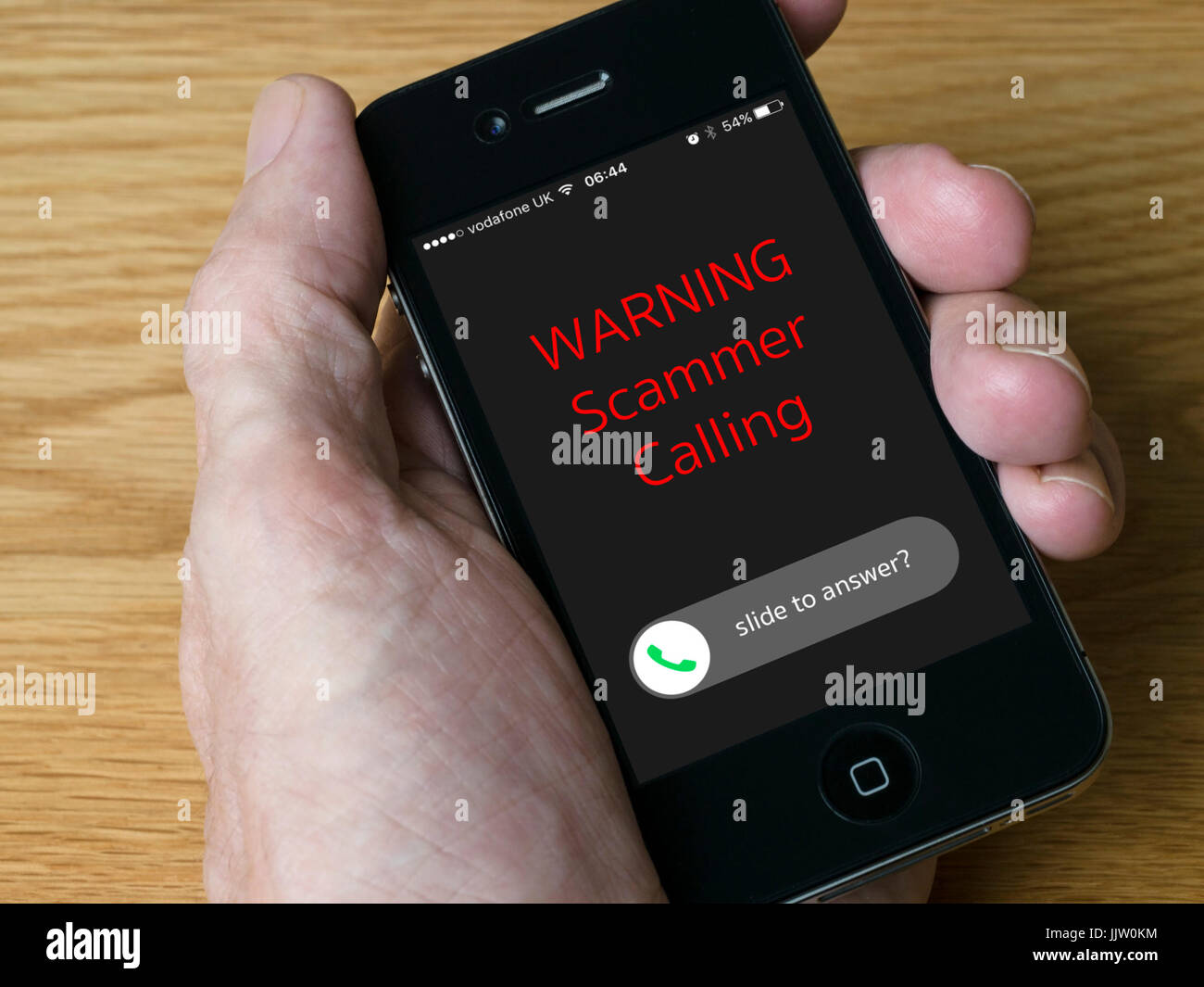 Konzept Bild - Warnung - Eingehenden Anruf von scammer auf Handheld iPhone Handy Display Stockfoto