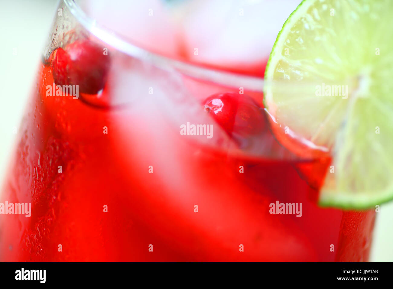 Nahaufnahme von Cranberry-Drink mit frische Cranberries und Limettenscheibe Stockfoto