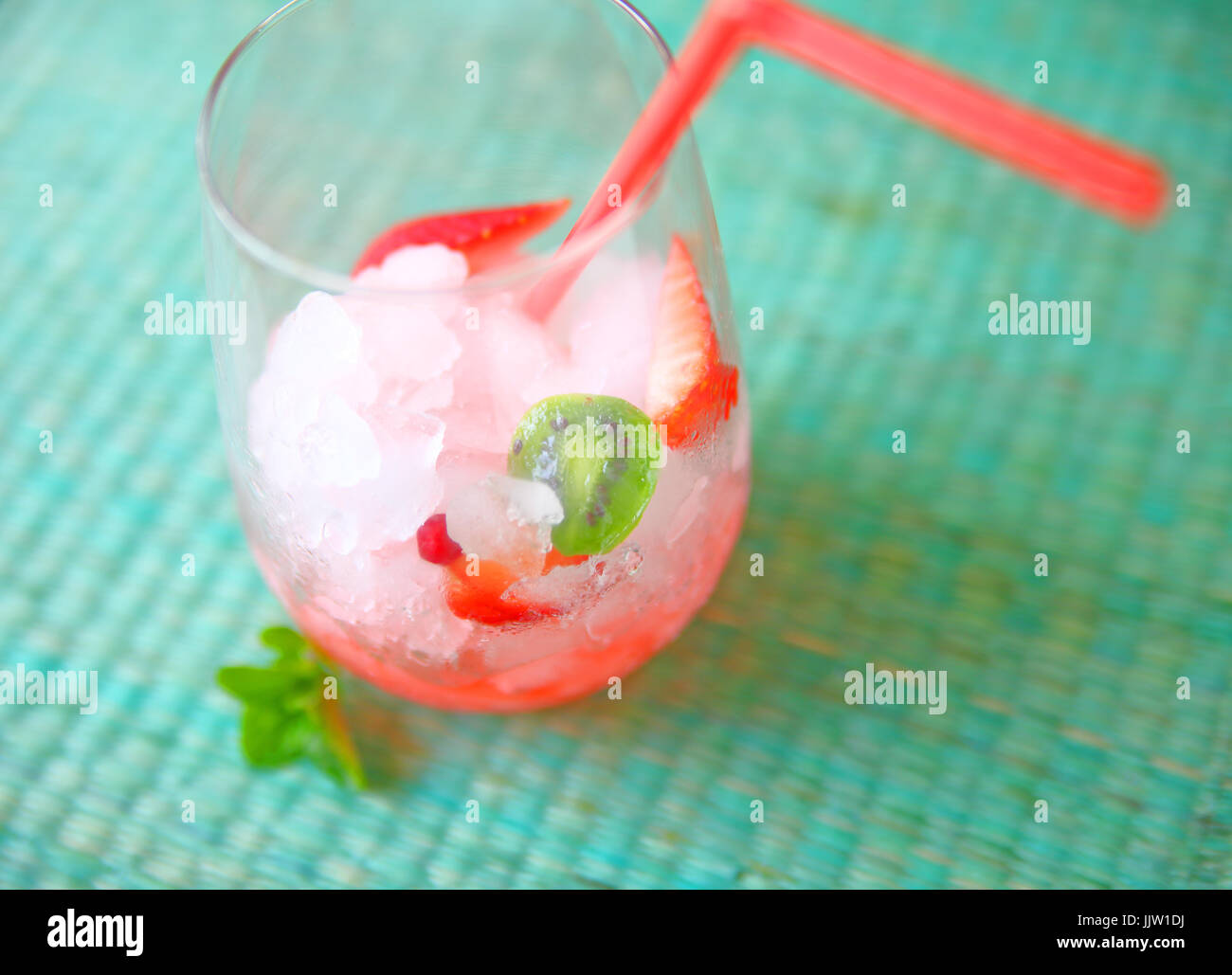 Zerstoßenes Eis mit schneiden Erdbeeren und Baby Kiwis mit einem Strohhalm mit Platz für text Stockfoto