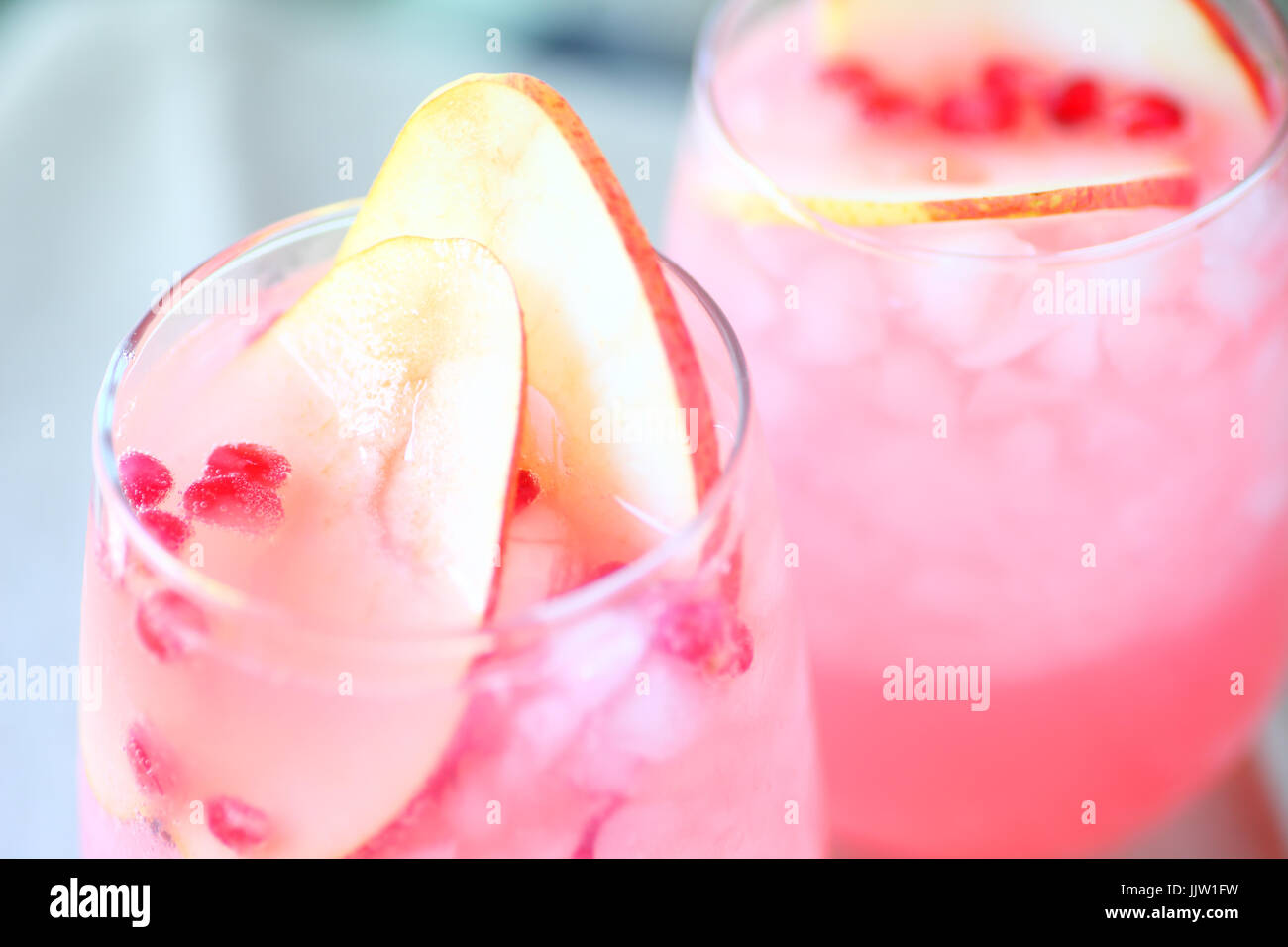 Nahaufnahme von zwei Gläser Blush Wein mit frischen Birnenspalten und Granatapfelkernen Stockfoto