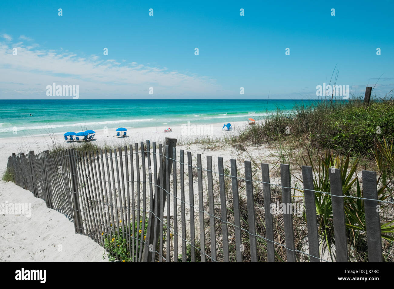 Weißer Sand und Dünen, die durch Sea Oats geschützt Grüße Familien in einem beliebten Destin Strand, Meer, an der Golfküste von Florida, USA. Stockfoto