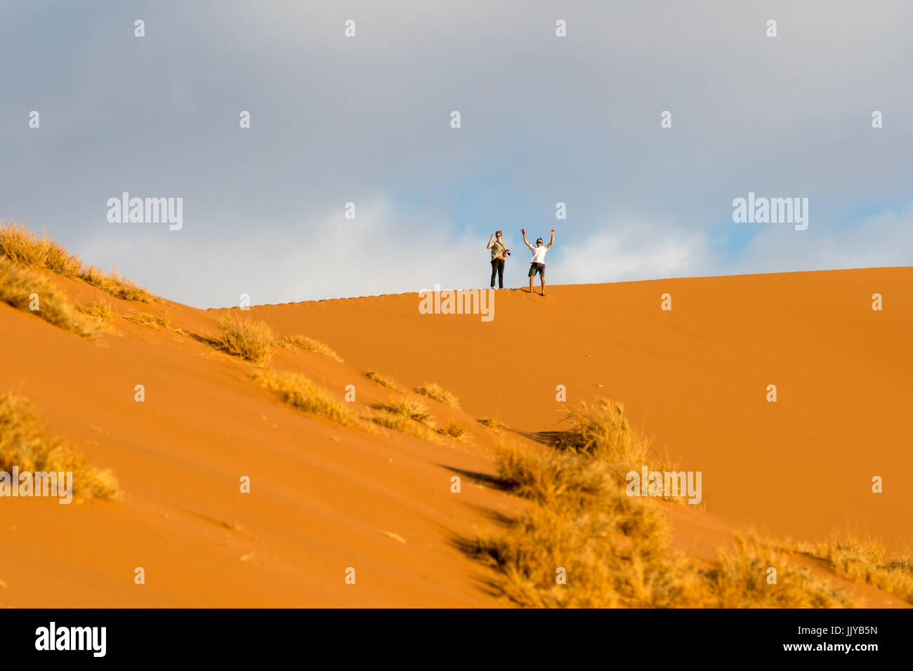 Touristen stehen oben auf der Düne 45, befindet sich über 170 Meter hoch, in den Soussuvlei Salzpfanne in Namib-Naukluft Nationalpark in Namibia, Afrika. Stockfoto