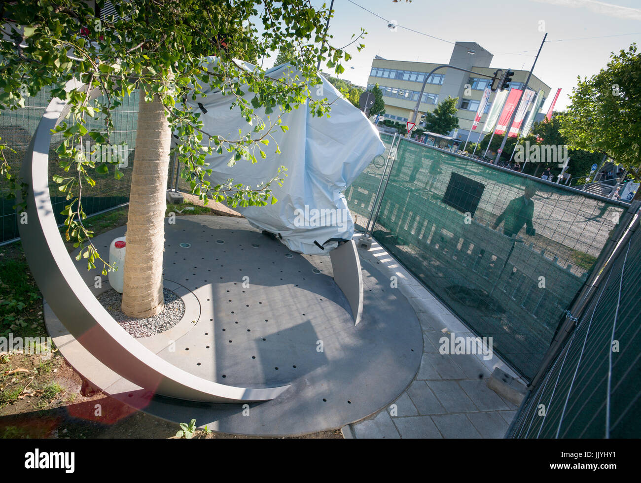 München, Deutschland. 21. Juli 2017. Ein Denkmal in Form eines Rings um einen Baum ist immer noch bedeckt und umgeben von einem Zaun in unmittelbarer Nähe des Olympia-Einkaufszentrum in München, Deutschland, 21. Juli 2017 ersichtlich. Am 22. Juli 2016 der 18-jährige Student David S. 9 Personen erschossen und verwundet andere vor der Einnahme von seinem eigenen Leben rund um das Olympia-Einkaufszentrum im Münchner Stadtteil Moosach. Foto: Peter Kneffel/Dpa/Alamy Live News Stockfoto