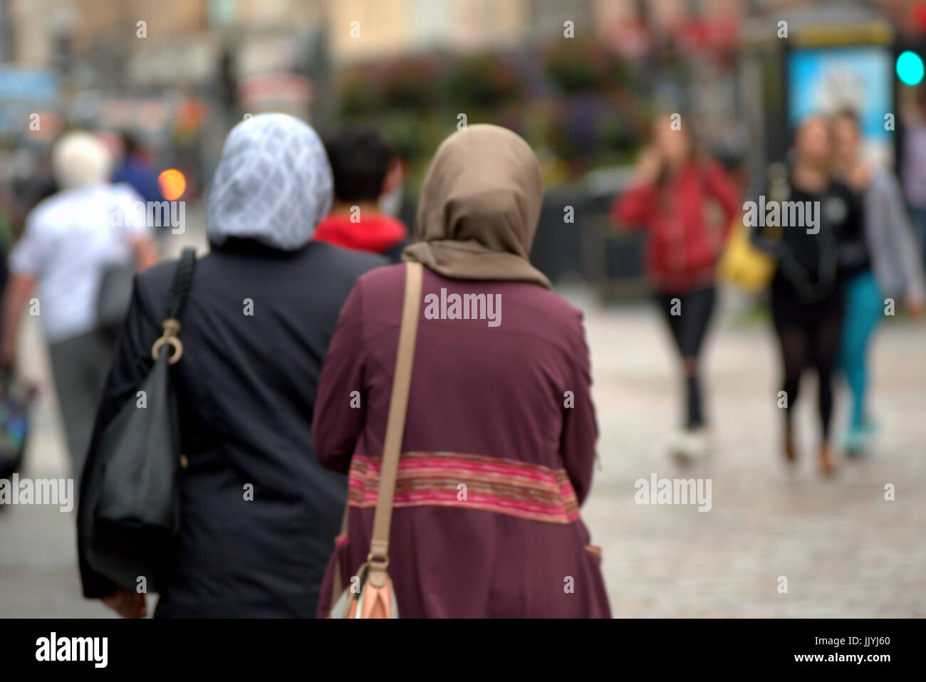 Asiatische Flüchtlinge gekleidet hijab Schal auf der Straße in Großbritannien alltägliche Szene Opfer bedroht junge weiße Mädchen Stockfoto