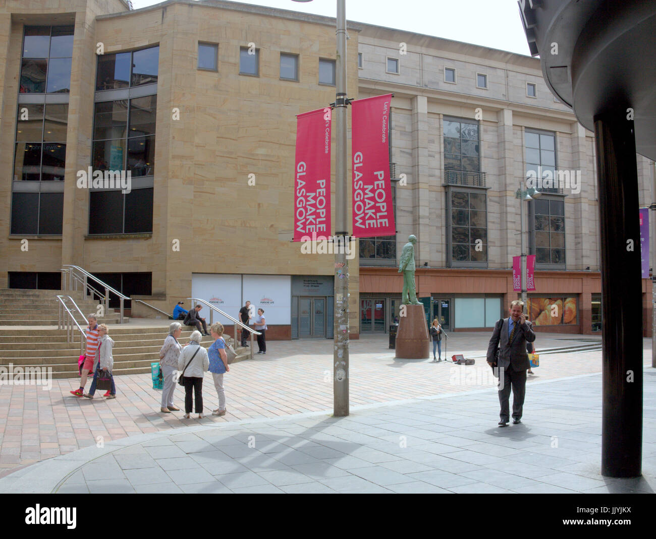 Menschen machen Glasgow Donald Dewar Statue Sonnenschein royal Comcert Hall Schritte Geschäftsmann auf Telefon zu Fuß Stockfoto