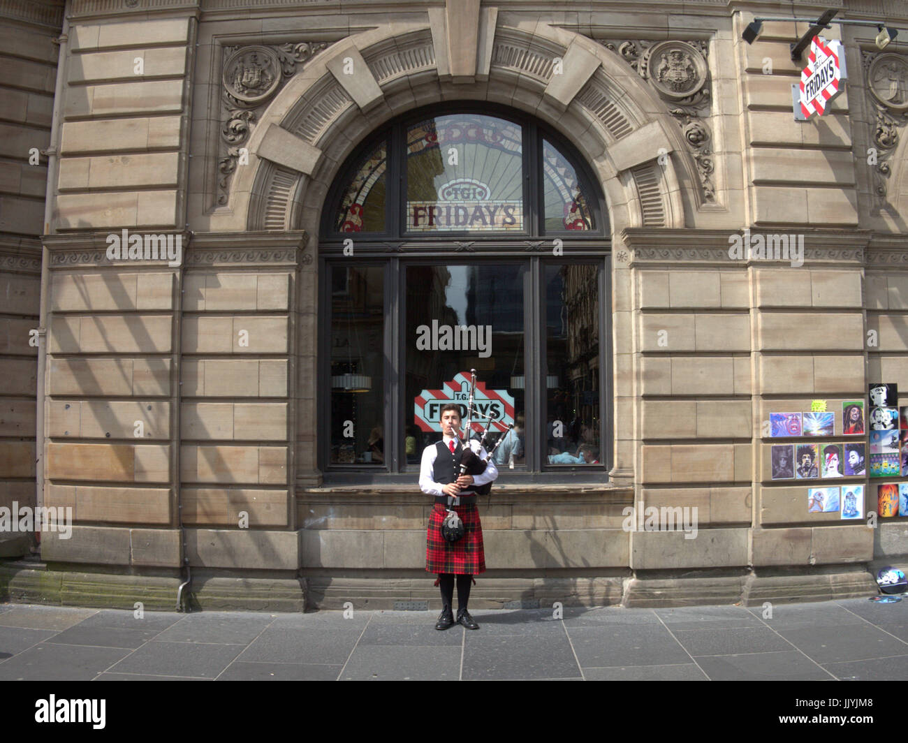 TGI Fridays Glasgow Buchanan Street Pfeifer in einem Kilt gerahmt im Fenster Stockfoto