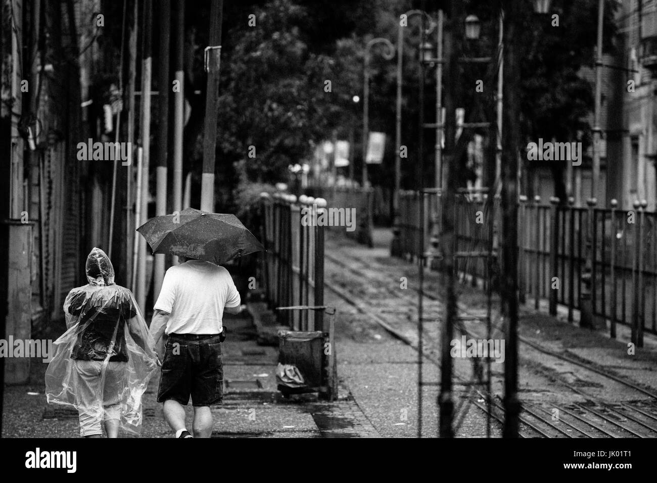 Touristischen paar halten Hände im Regen, bei einem Spaziergang rund um La Boca in Buenos Aires, Argentinien. Stockfoto