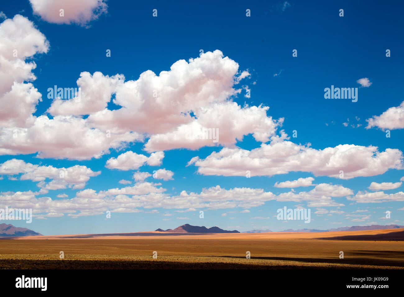Große, flauschige Wolken und einen freien Blick auf die Wüstenlandschaft in der Namib-Naukluft-Nationalpark in Namibia, Afrika. Stockfoto