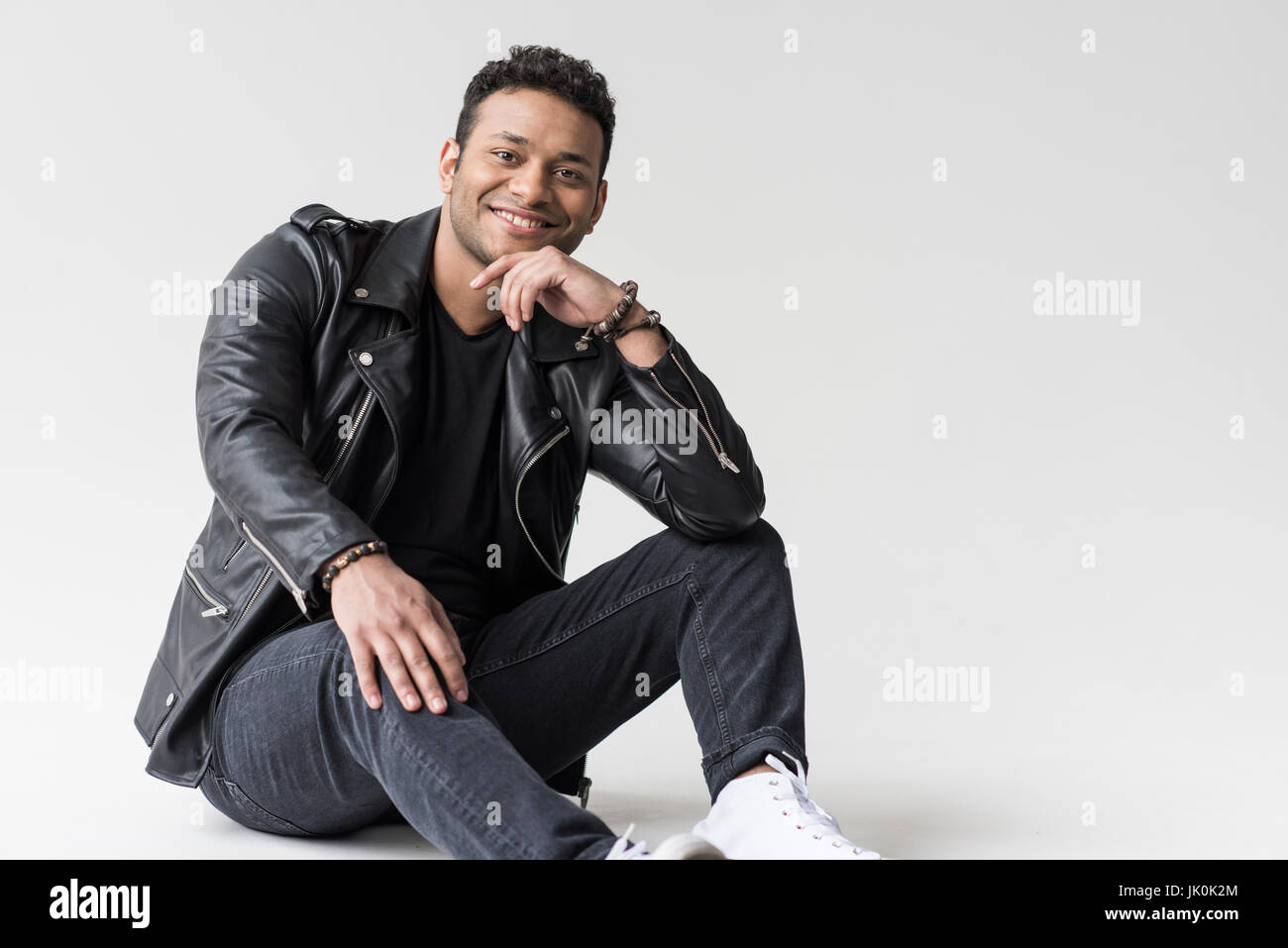 junge afrikanische amerikanischer Mann lächelnd auf grau isoliert Stockfoto