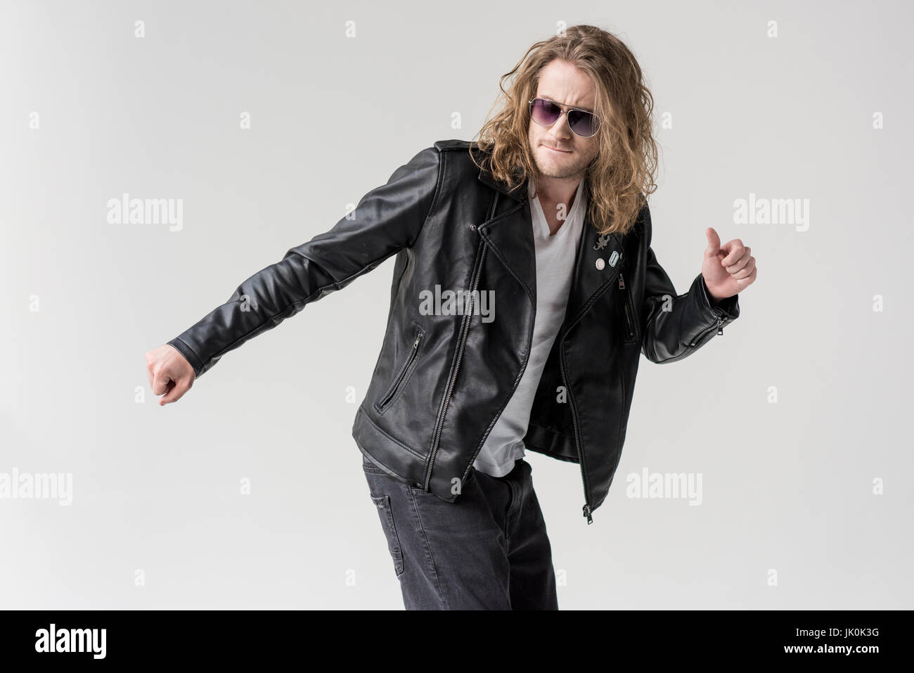 schönen jungen Mann in schwarzem Leder Jacke tanzen isoliert auf grau Stockfoto