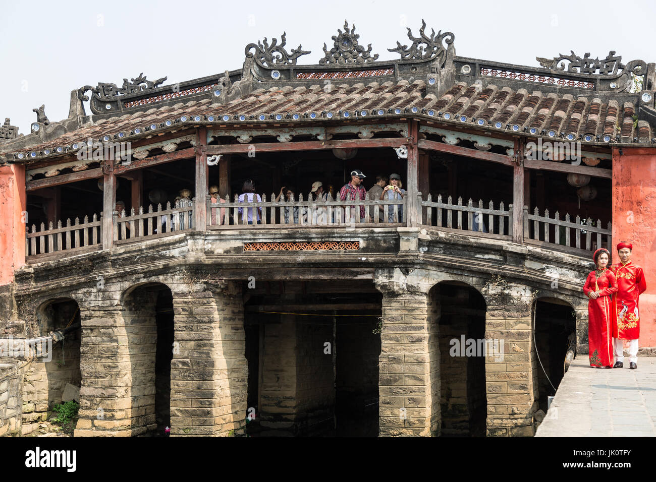 Ein paar Posen für Hochzeitsfotos vor die berühmte japanische Brücke in Hoi an eine möglichst bedeckt Touristen strömen in die Brücke Stockfoto
