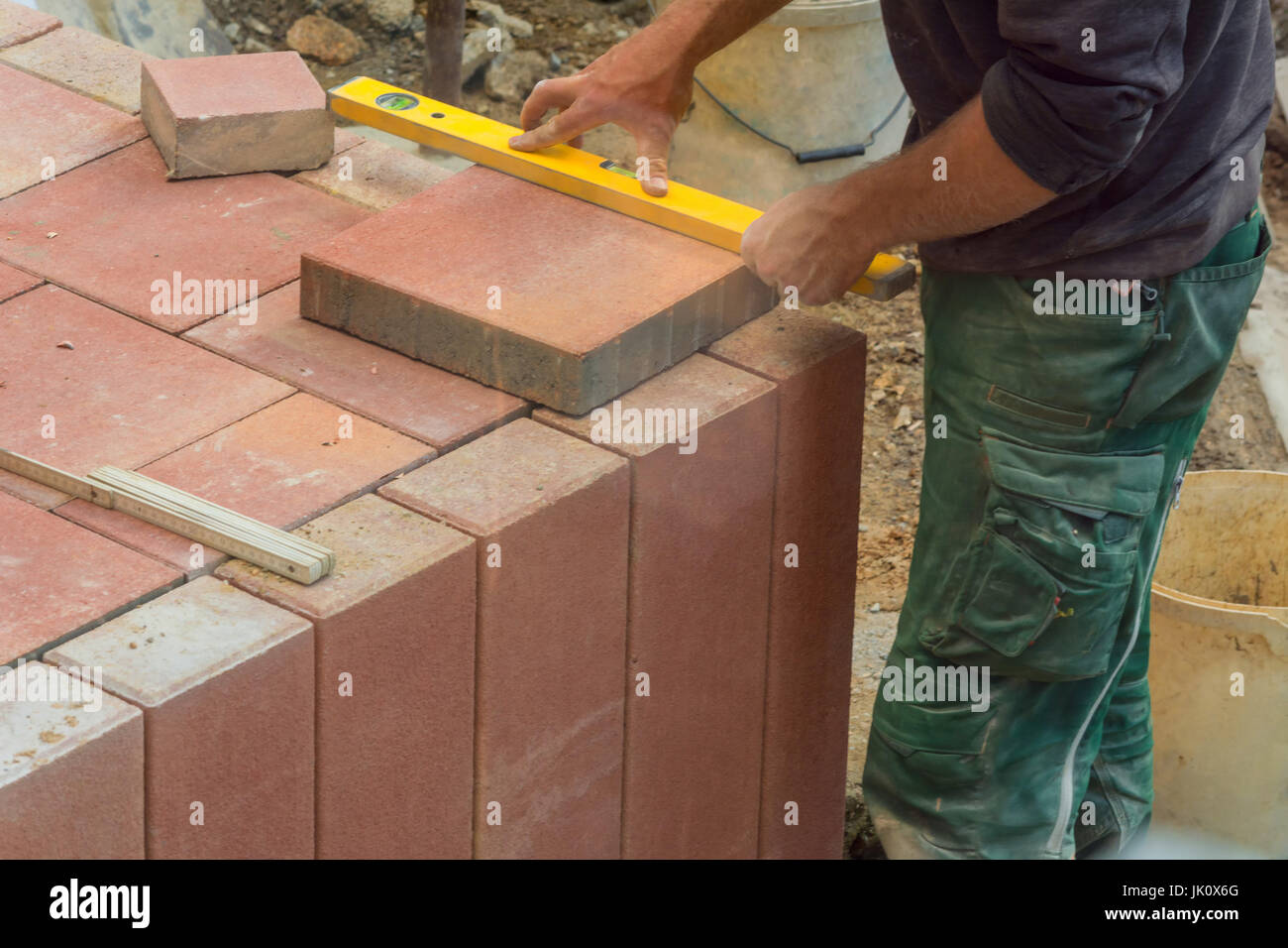 Mann schneiden Steinplatten, Betonplatte mit einer elektrischen Schleifer Stockfoto
