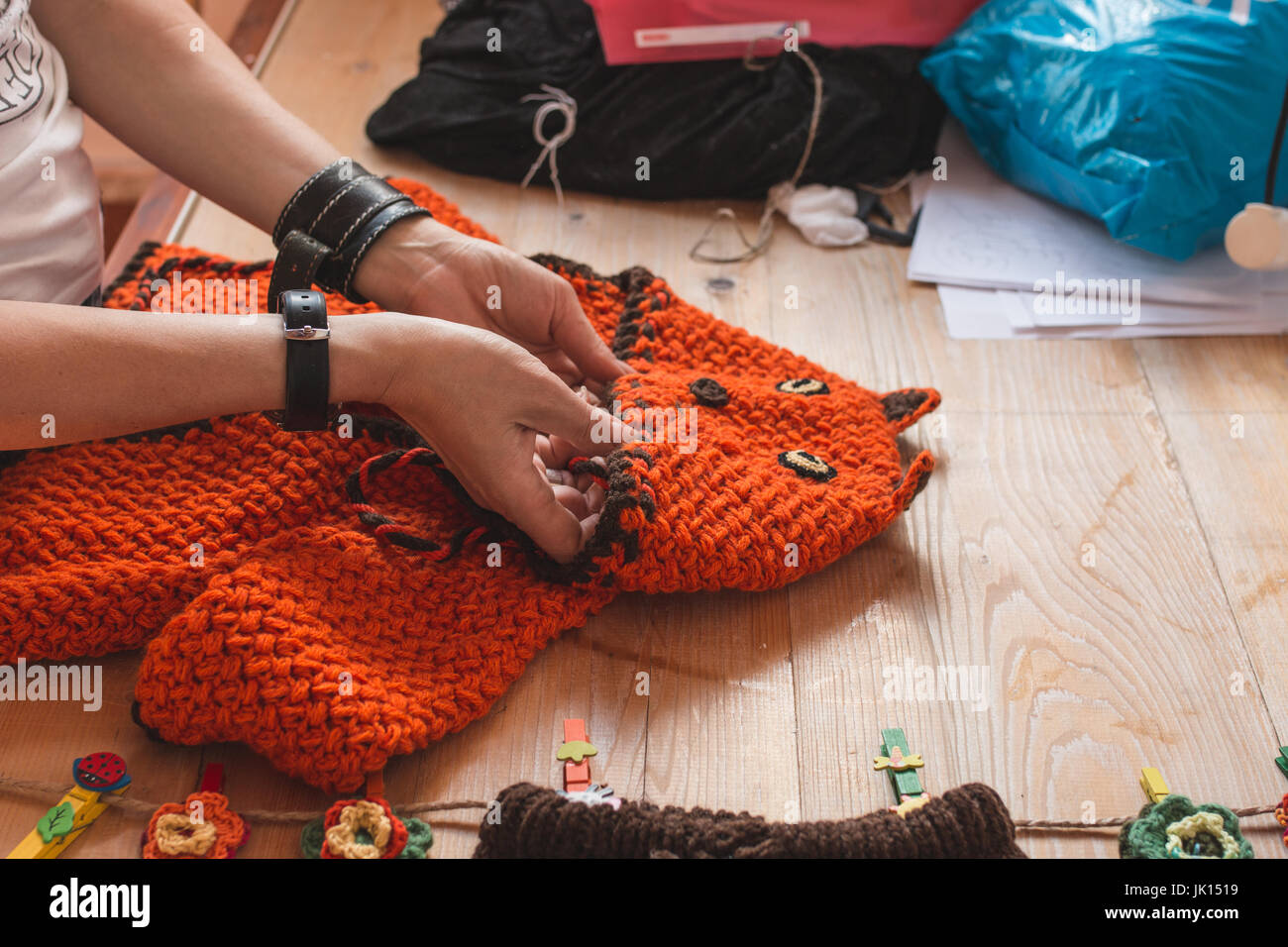 Frau Hände Qualitätsprüfung Hand gewebt Pullover auf einem Holztisch Stockfoto