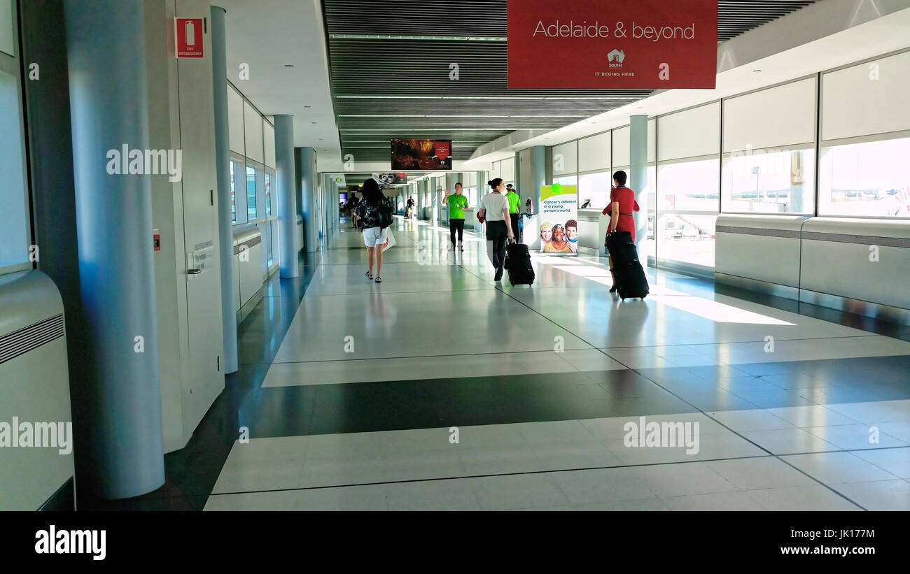 Passagiere und Flugbegleiter zu Fuß in Richtung Abflug-Lounges am Flughafen Stockfoto