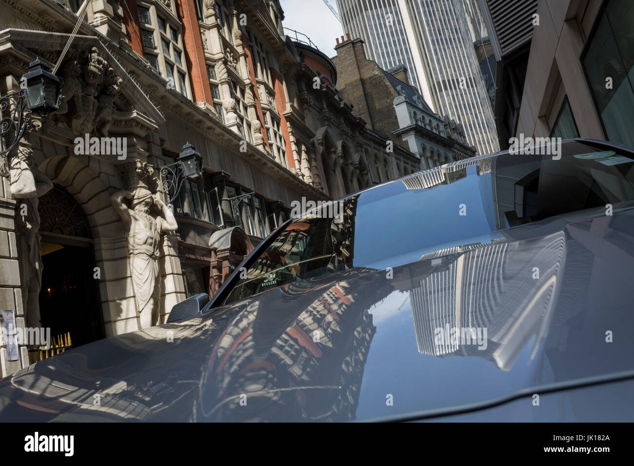 Türme und Architektur der Tuchmacher Halle inklusive Atlantes Figuren des Bildhauers H.A. Pegram, spiegelt sich in der Motorhaube eines Autos geparkt in Throgmorton Street, am 17. Maschinenbautag 2017 in der City of London, England. Die Tuchmacher Company ist eine Lackierung in der City of London, dessen Wurzeln zurück bis ins 13. Jahrhundert gehen, als wie der Name andeutet, war es im Handel mit Drapierung beteiligt. Während es im Handel nicht mehr beteiligt ist, hat das Unternehmen entwickelt eine neue Relevanz zu erwerben. Seine wichtigste Aufgabe besteht heute zu der Treuhänder die Stiftungen, die im Laufe der Jahrhunderte in seine Obhut gelassen haben. Die Co Stockfoto