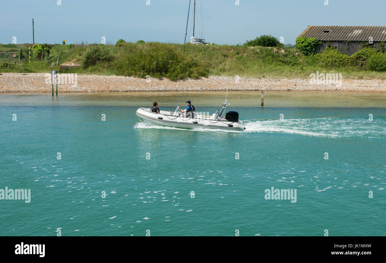 Starre aufblasbare Motorboot (RIB) mit Außenbordmotor und zwei Personen auf den Fluss Arun in Littlehampton in West Sussex, England Stockfoto