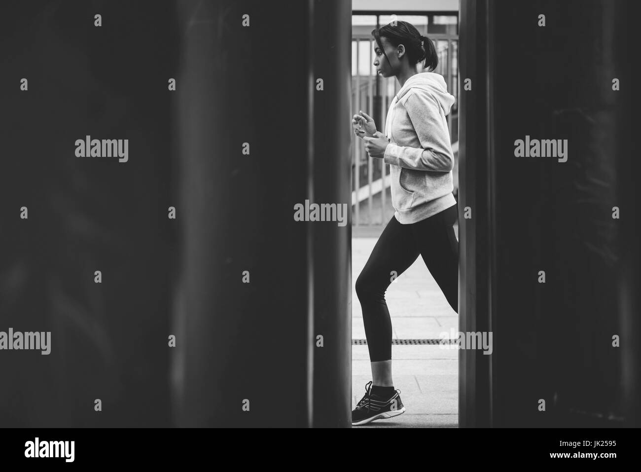 Seitenansicht des jungen Fitness Frau in Sportbekleidung Joggen am Stadion, schwarz / weiß Foto Stockfoto