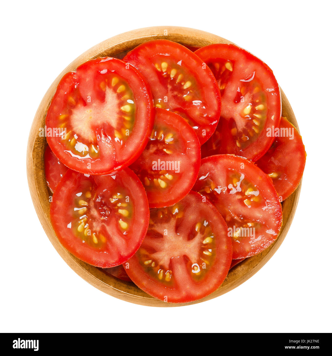 Tomatenscheiben in Holzschale. Essbare reif und rohe Frucht von Solanum Lycopersicum mit rot, in dünnen Splittern schneiden. Isolierte Makrofoto Essen. Stockfoto