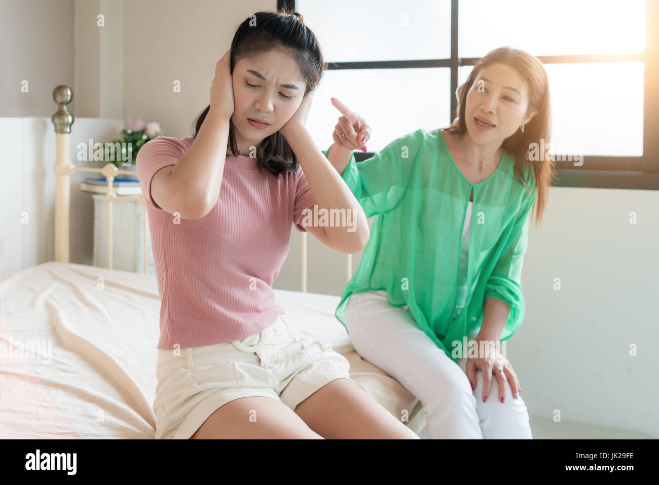 Schöne asiatische Mutter ist ihre Teenager-Tochter schelten, Mädchen ihrer Mutter ignoriert. Stockfoto