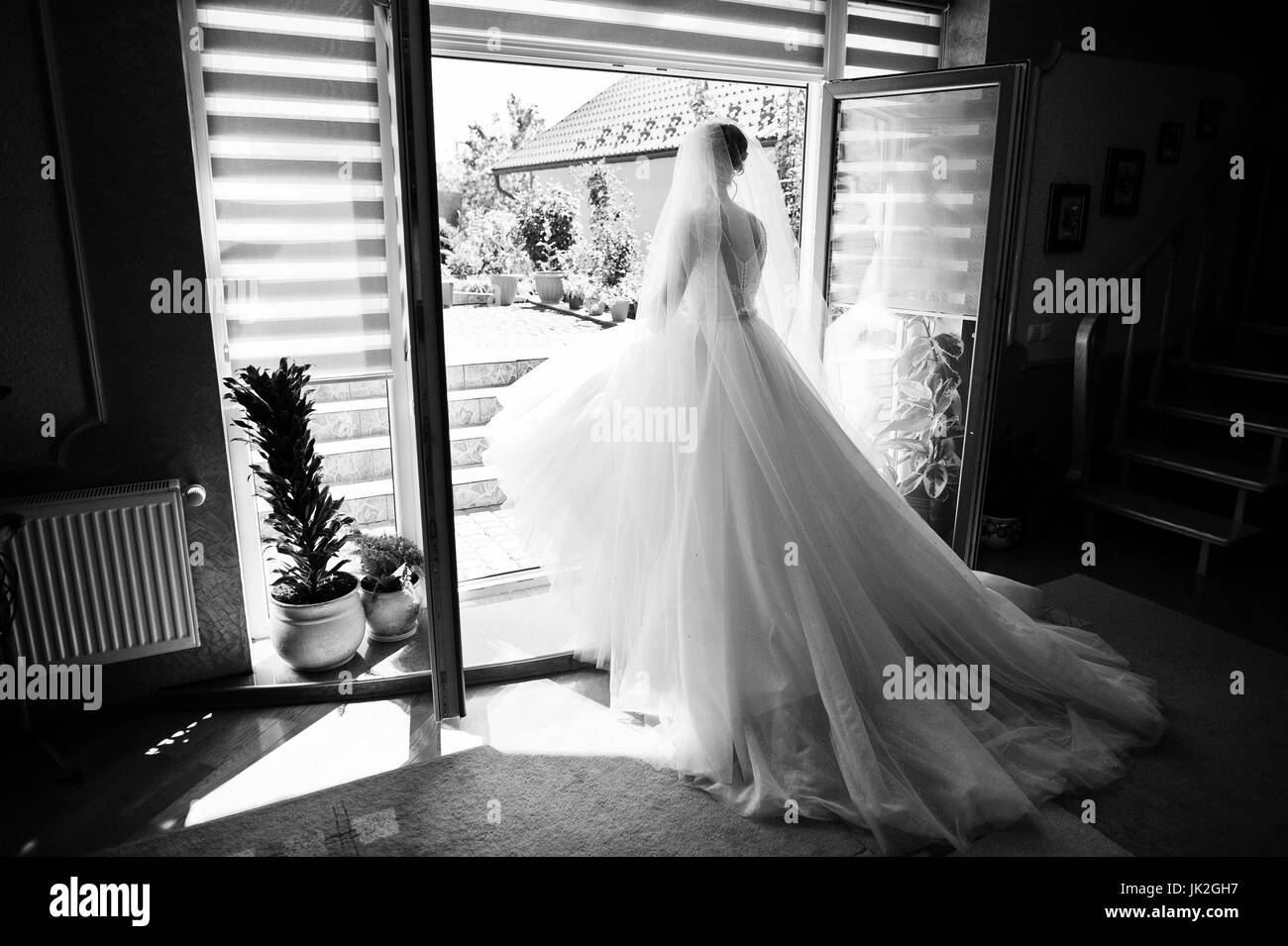 Porträt einer fabelhaften Braut posiert in ihrem Haus am Tag Hochzeit. Schwarz / weiß Foto. Stockfoto