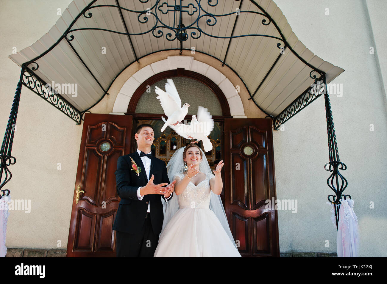 Awesome Hochzeitspaar Freisetzung von Tauben in den Himmel. Stockfoto