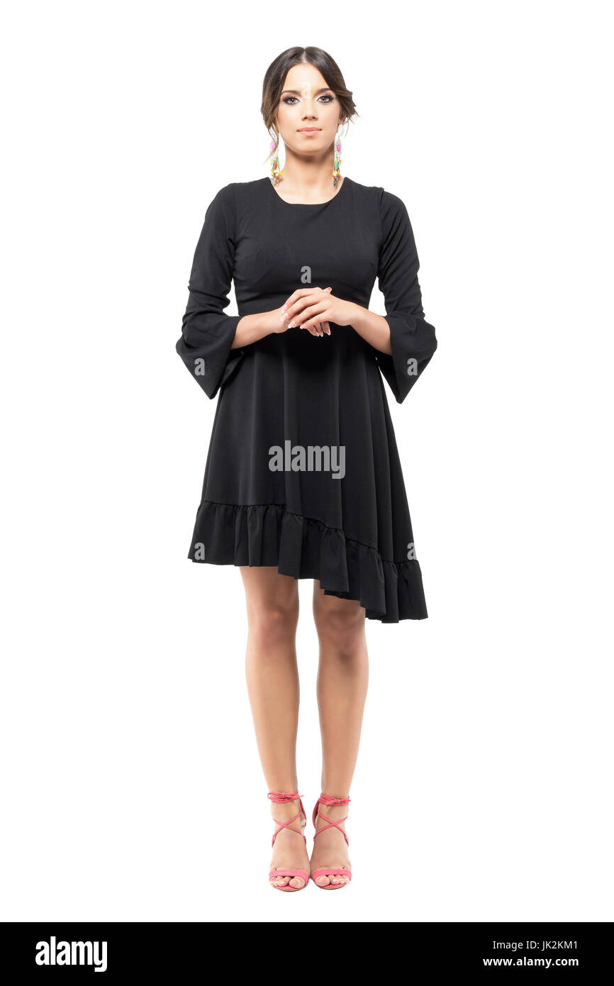 Stehen edel formale Frau im schwarzen Kleid mit Hand umklammert, Blick in die Kamera. Ganzkörper-Länge-Porträt isoliert auf weißem Hintergrund. Stockfoto