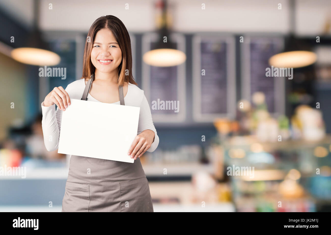 asiatische Unternehmer mit leerem Papier auf Bäckerei Shop Hintergrund Stockfoto