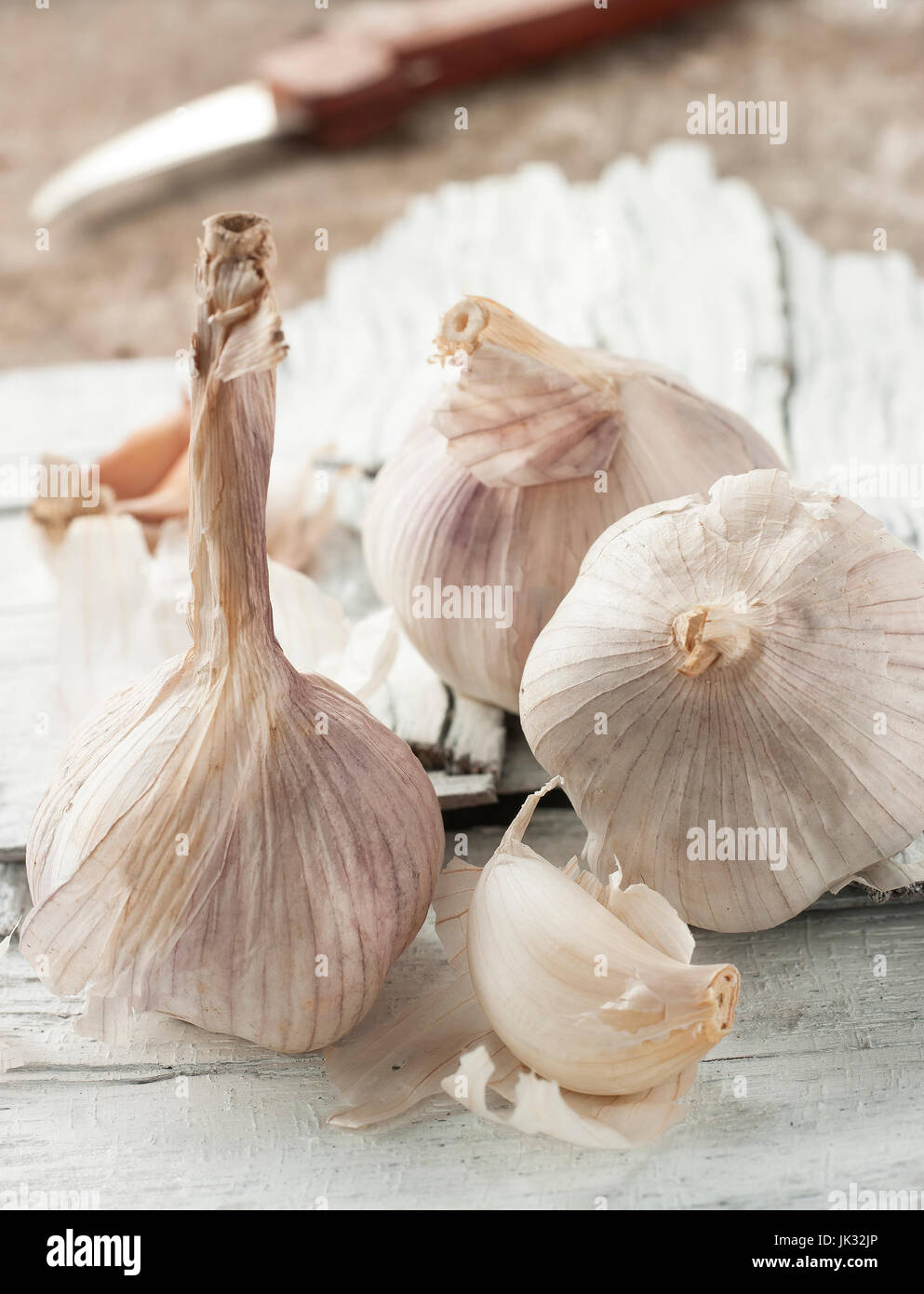 Stillleben-Kunst von Knoblauch auf hölzernen Hintergrund mit Messer Stockfoto