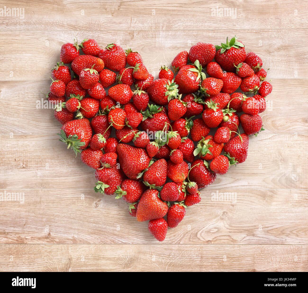 In Herzform aus Erdbeere auf hölzernen Hintergrund. Obst-Diät-Konzept. Hautnah. Ansicht von oben. Hohe Auflösung Stockfoto