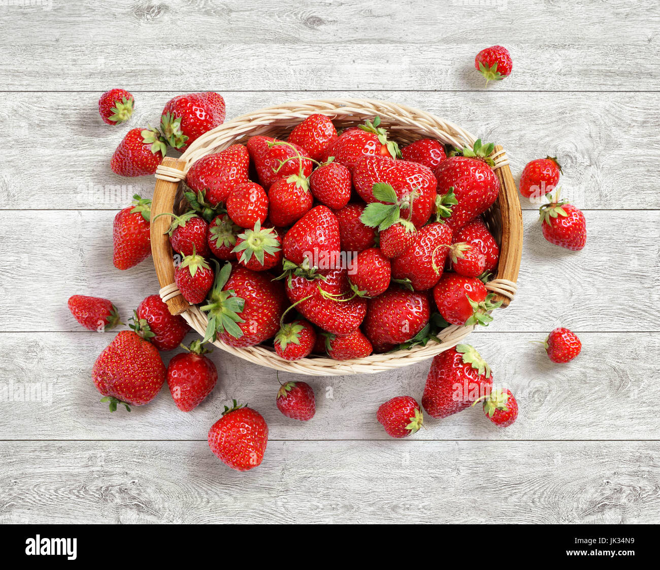 Frische Erdbeeren im Korb auf weißem Hintergrund aus Holz. Ansicht von oben. Hohe Auflösung. Ernte-Konzept Stockfoto
