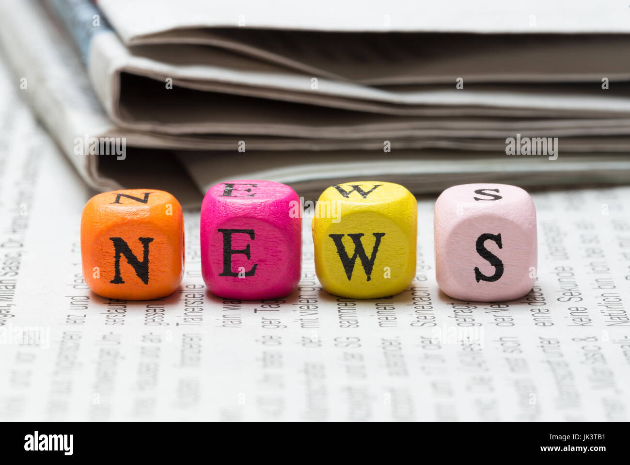 Nachrichten schreiben Cubes auf Zeitung Makro. Stockfoto