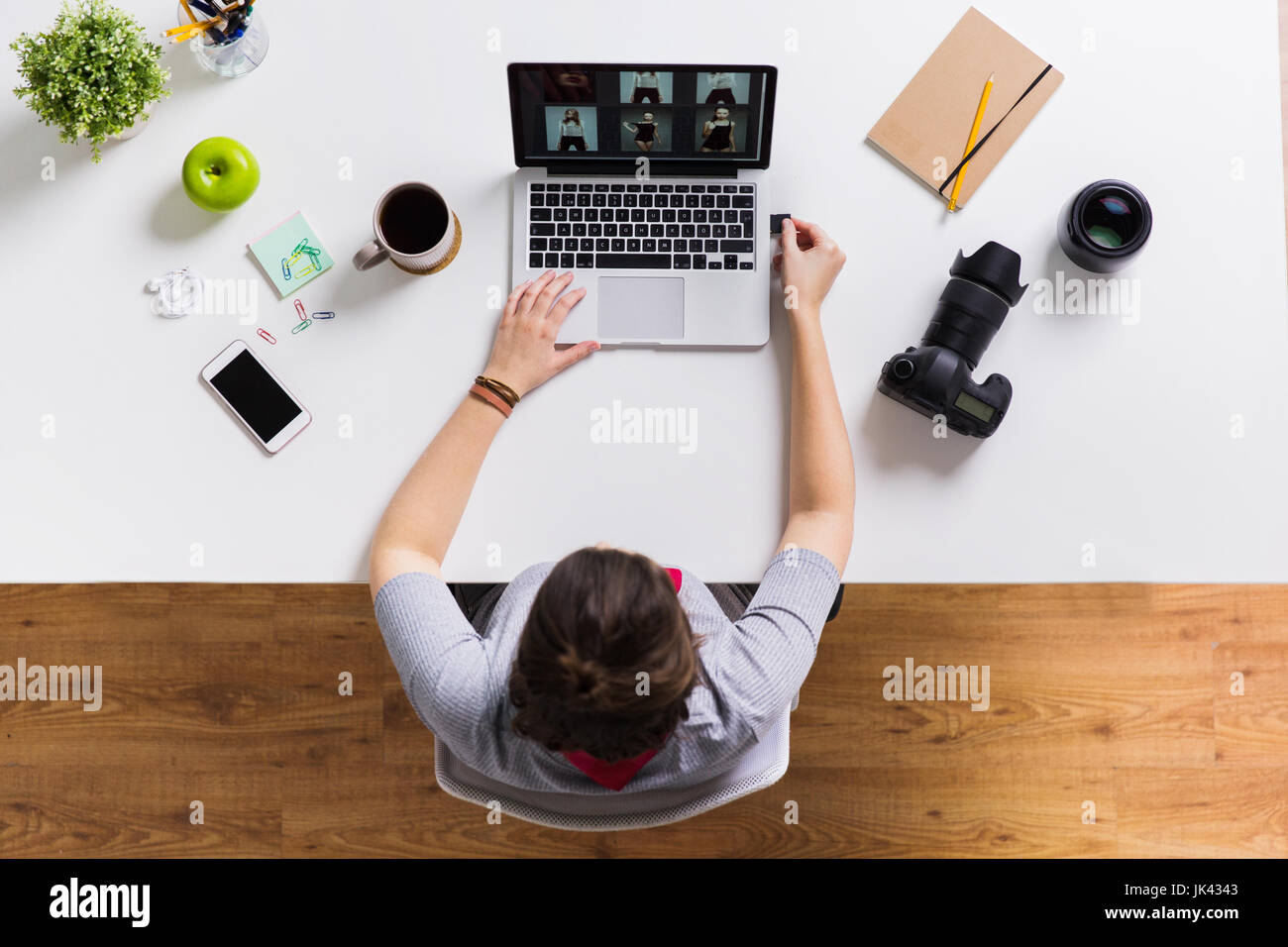 Frau mit Kamera-flash-Laufwerk und Laptop am Tisch Stockfoto