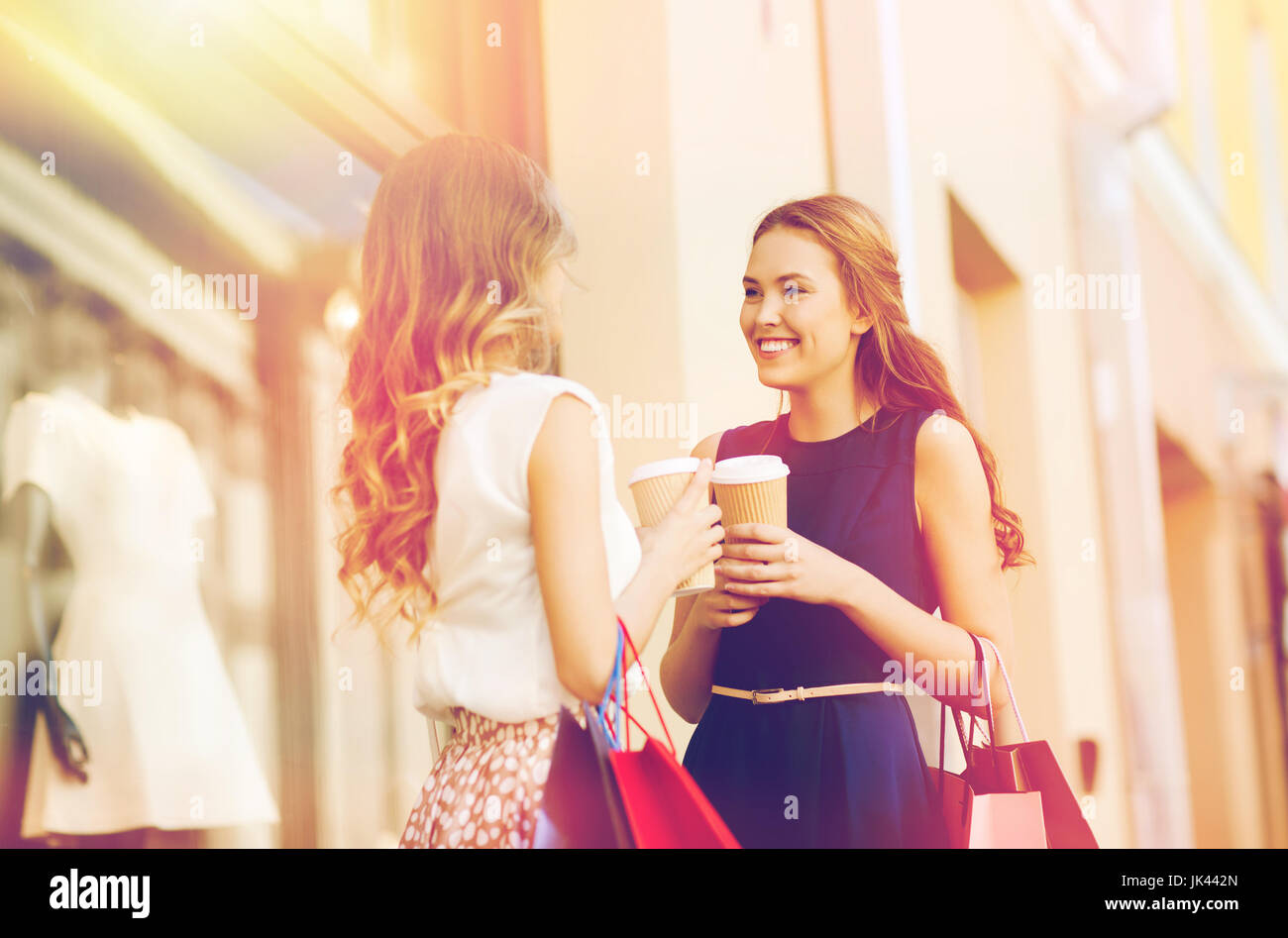 junge Frauen mit Einkaufstaschen und Kaffee Shop Stockfoto