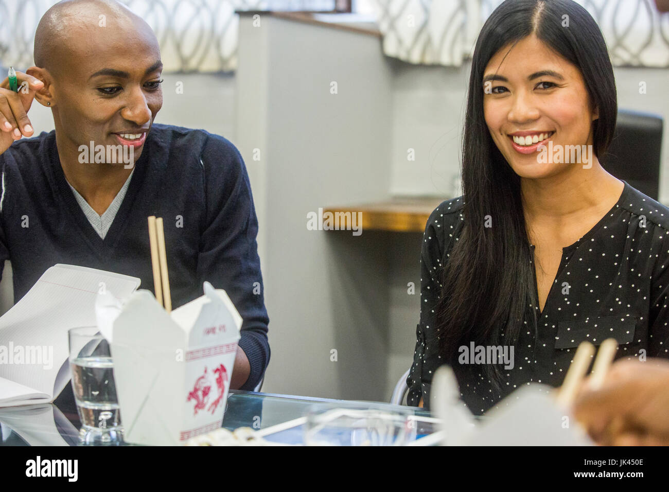 Lächelnde Menschen bei Treffen mit Kartons von Lebensmitteln Stockfoto