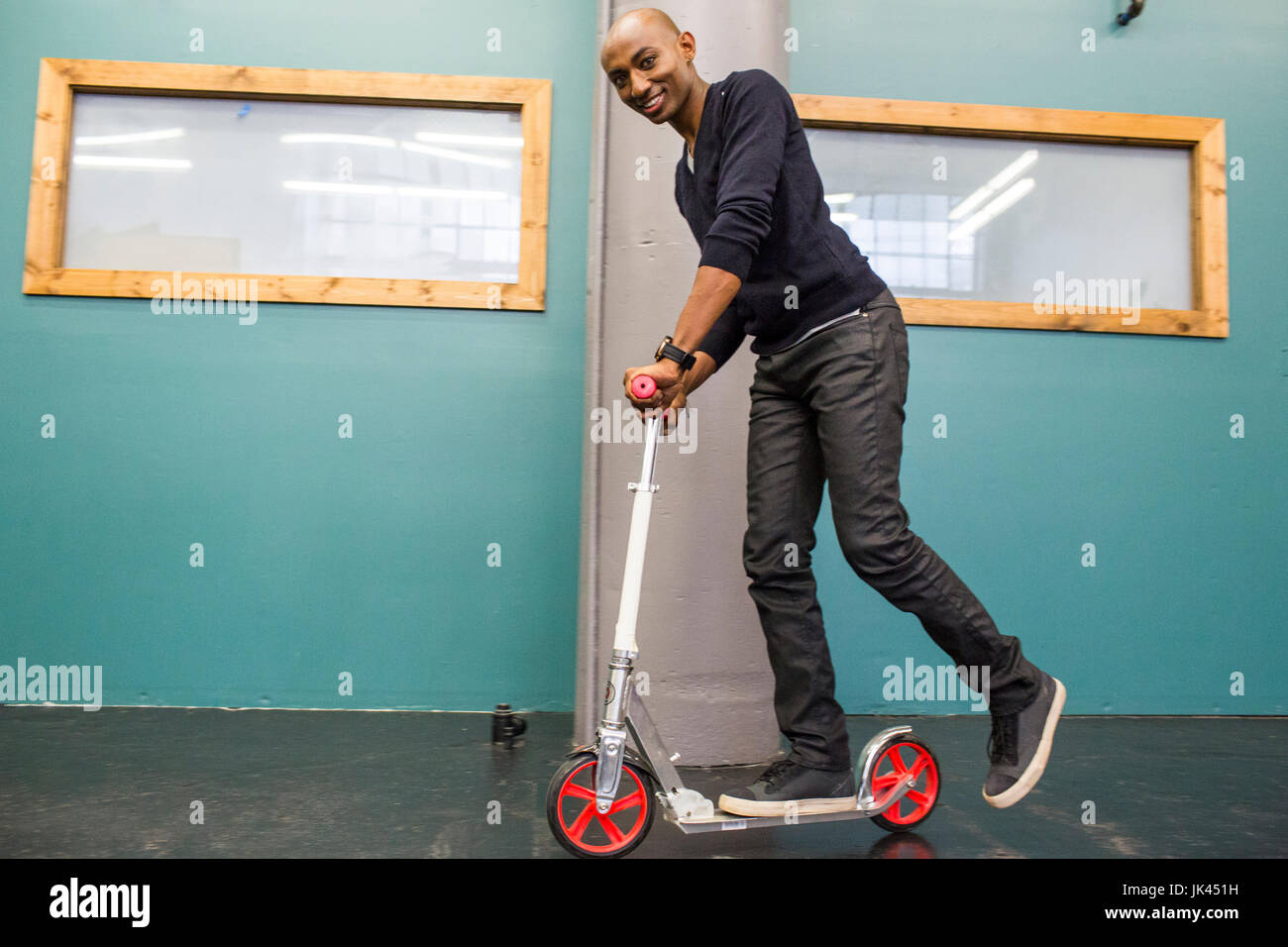 Afrikanische amerikanische Mann Reiten Scooter im Innenbereich Stockfoto