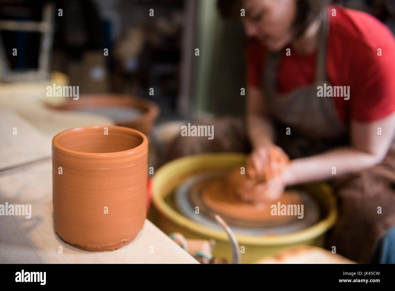 Cup in der Nähe von kaukasischen Frau Gestaltung Keramik Ton auf Rad Stockfoto