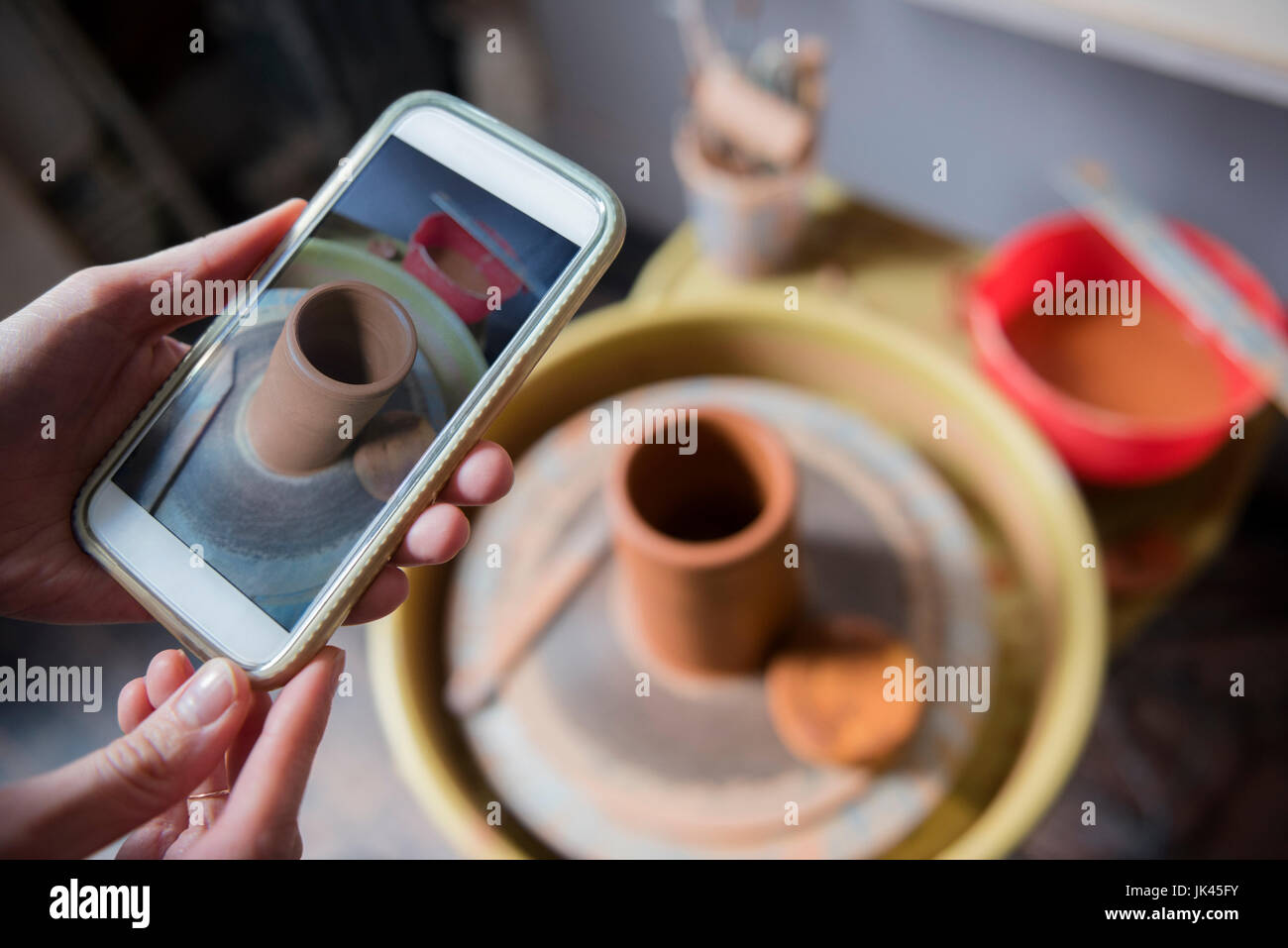 Händen der kaukasischen Frau fotografieren Keramik mit Handy Stockfoto