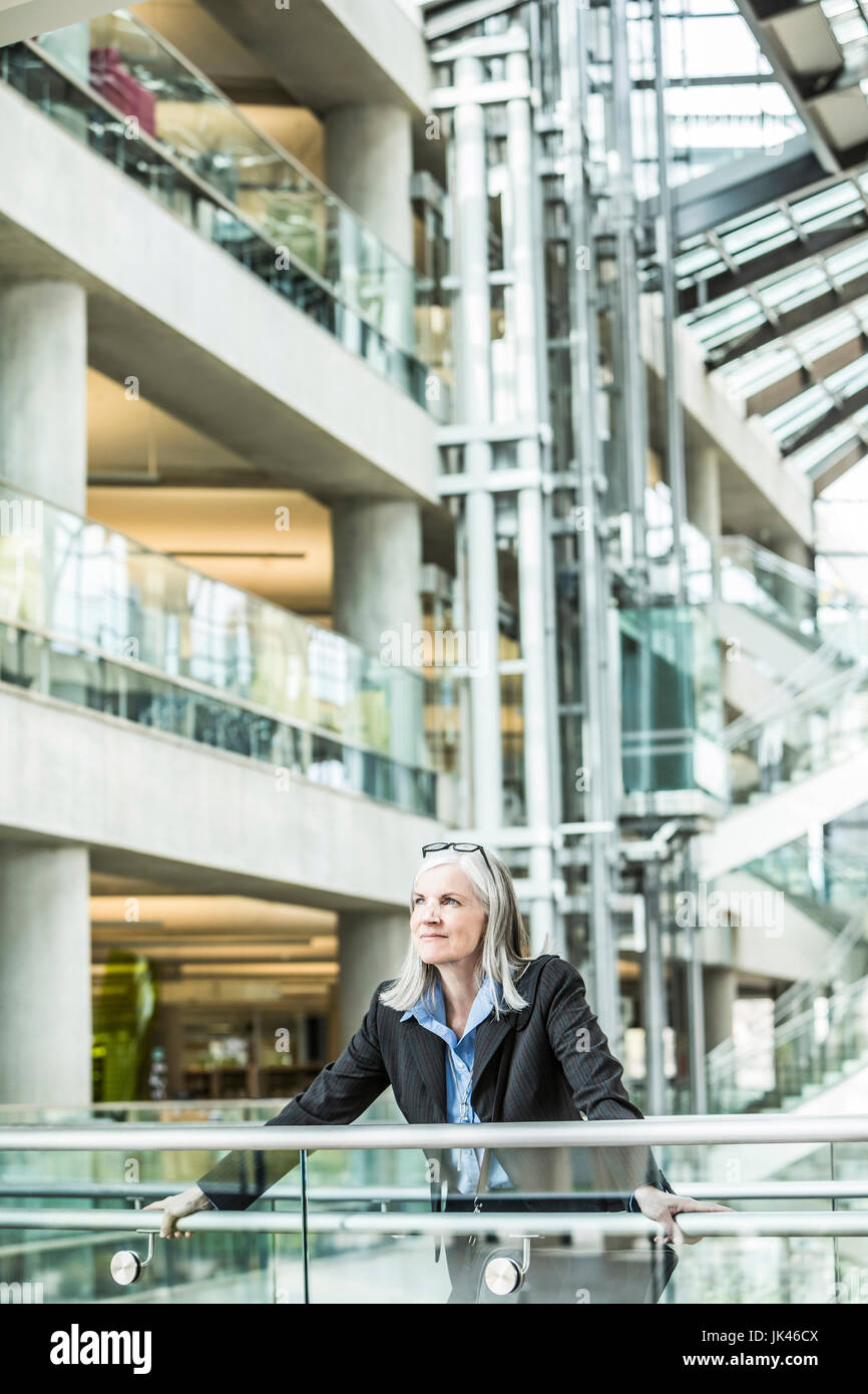 Porträt von nachdenklich kaukasischen Geschäftsfrau stützte sich auf Geländer in lobby Stockfoto