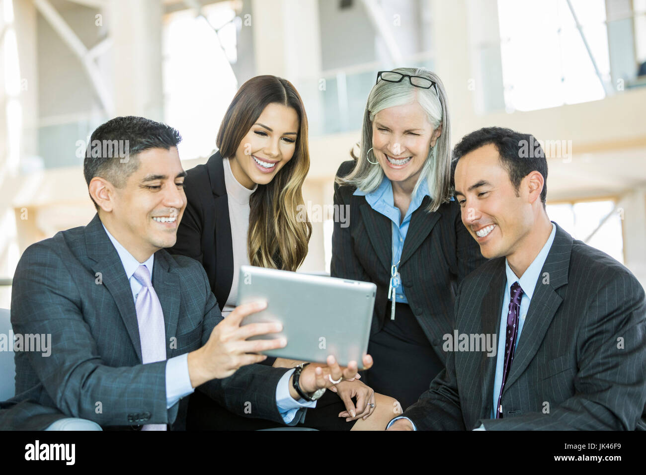 Lächelnde Geschäftsleute lesen digital-Tablette in lobby Stockfoto