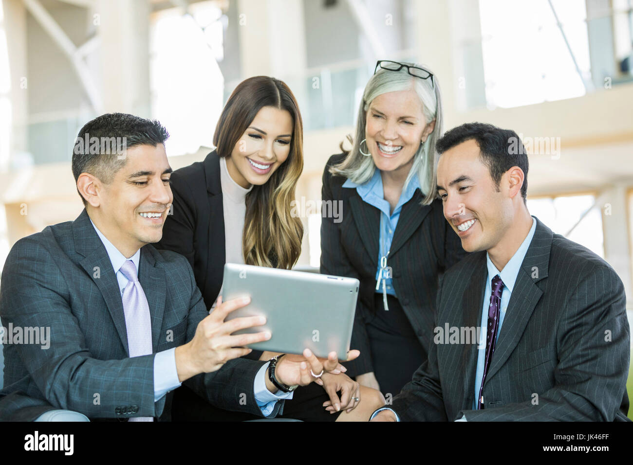 Lächelnde Geschäftsleute lesen digital-Tablette in lobby Stockfoto
