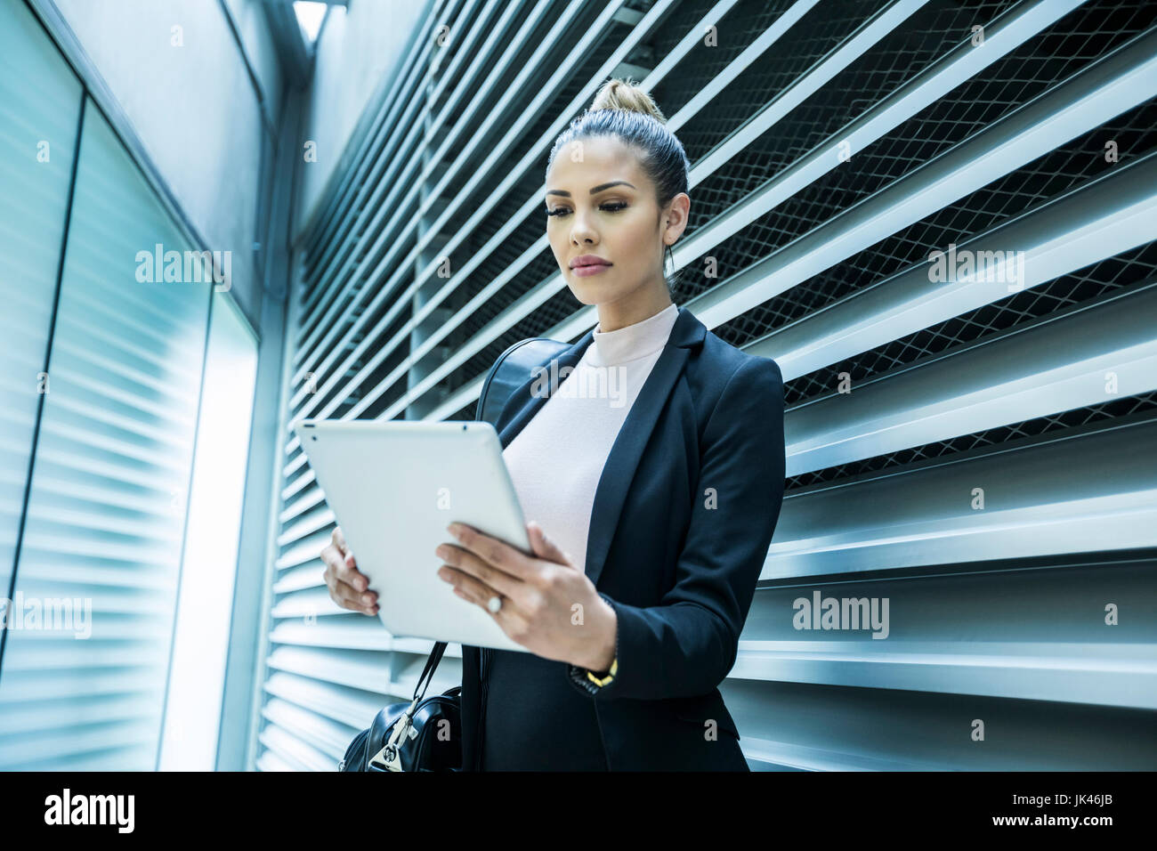 Ernsthafte Mischlinge Geschäftsfrau mit digital-Tablette im Korridor Stockfoto