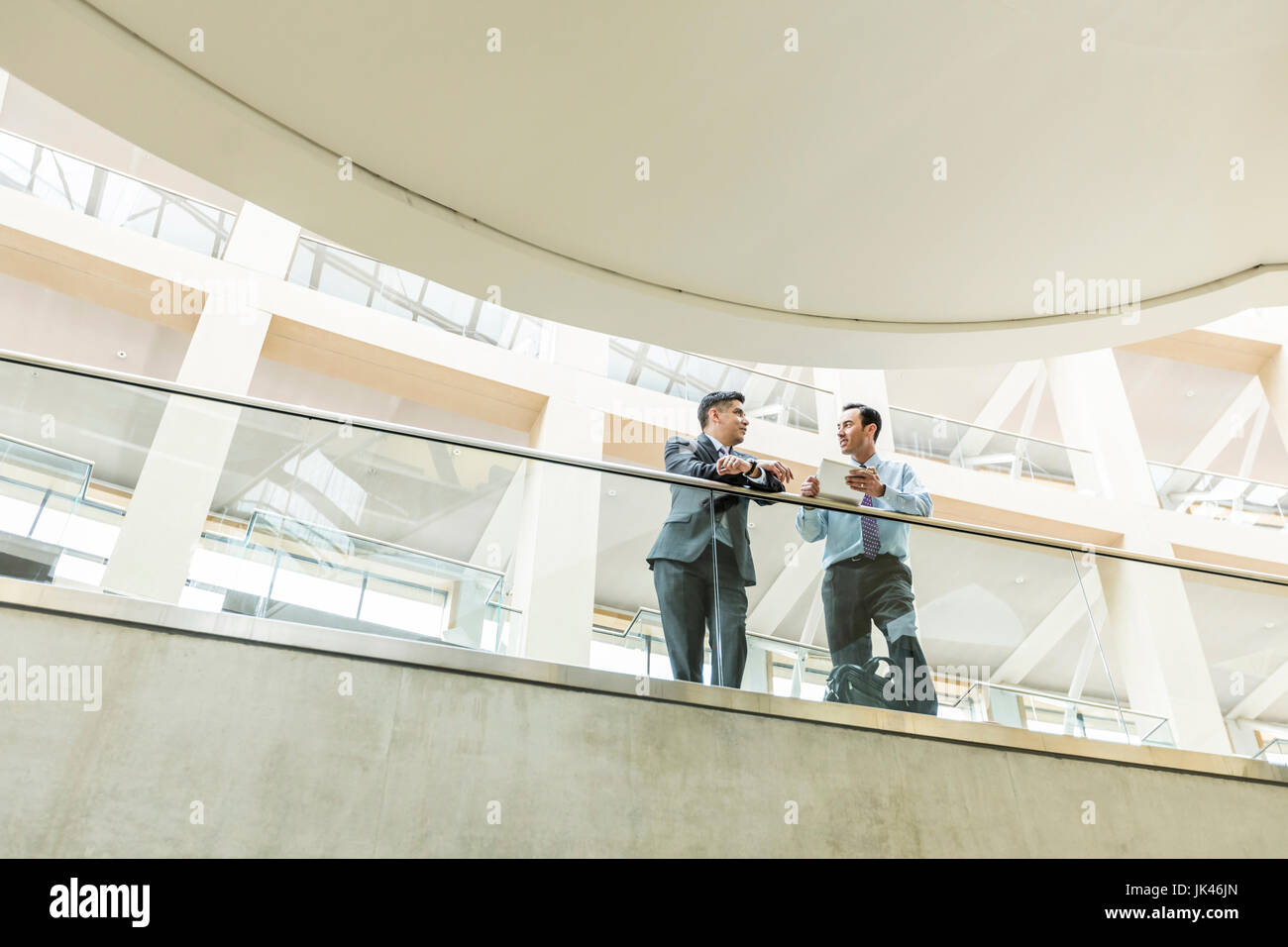 Gemischte Rennen Geschäftsleute sprechen in Lobby mit digital-Tablette Stockfoto