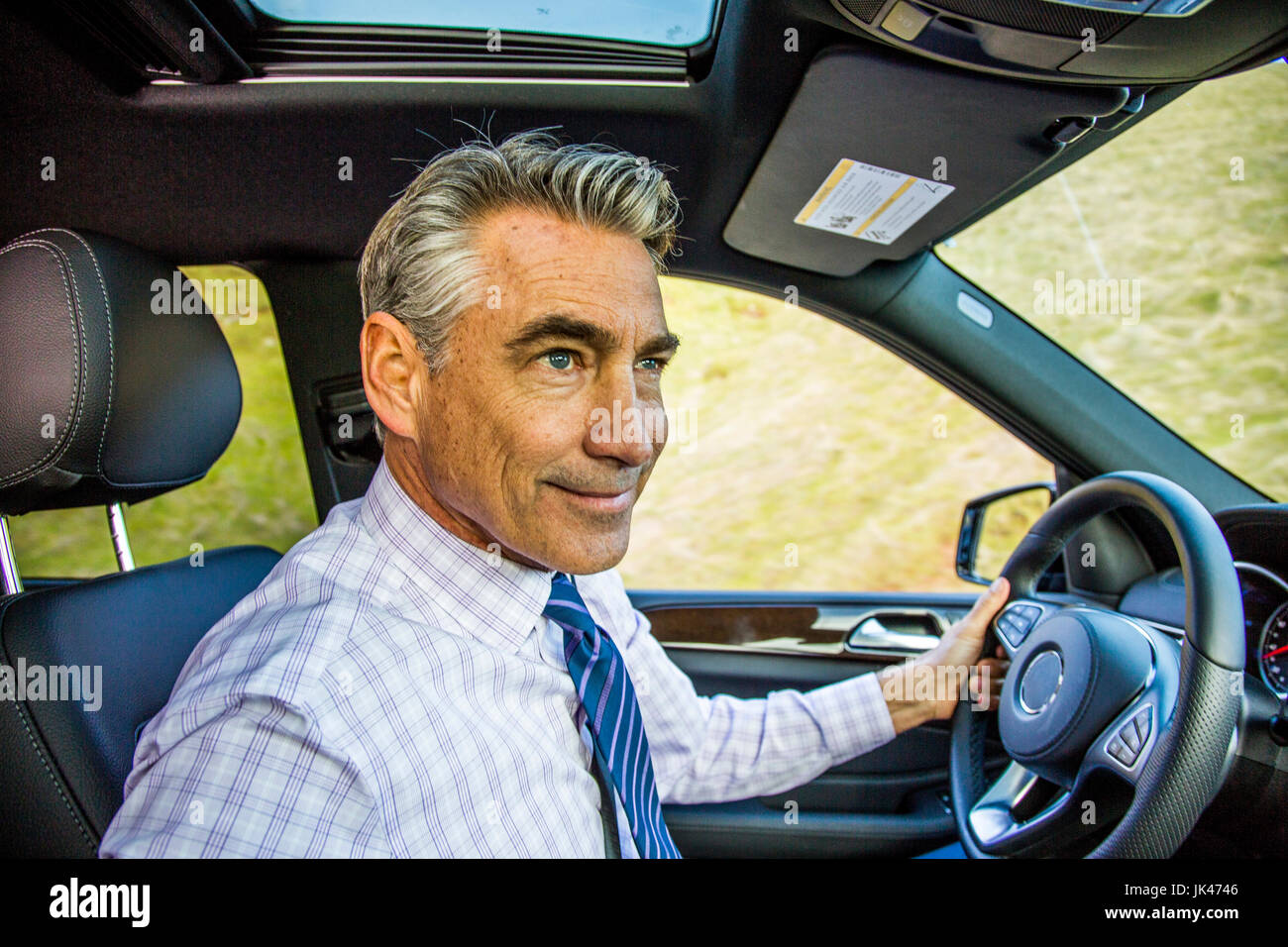 Lächelnd kaukasischen Geschäftsmann Auto fahren Stockfoto