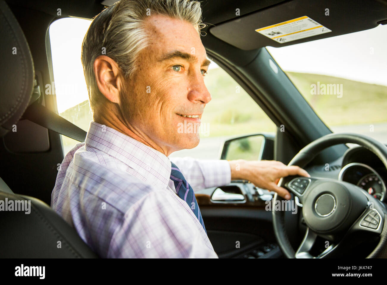 Lächelnd kaukasischen Geschäftsmann Auto fahren Stockfoto