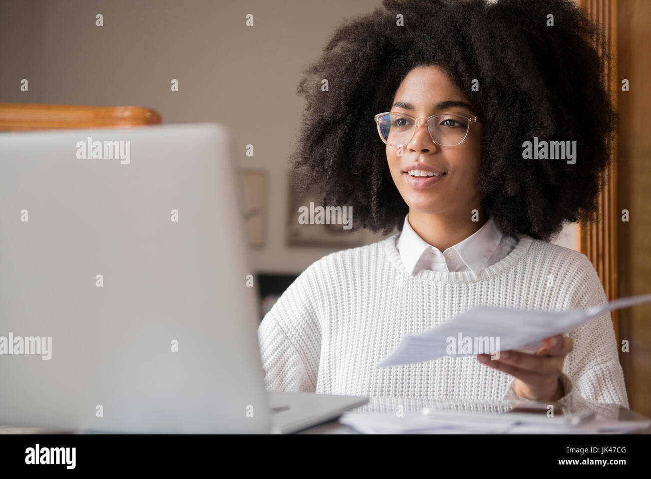 Afroamerikanische Frau mit Papierkram mit laptop Stockfoto
