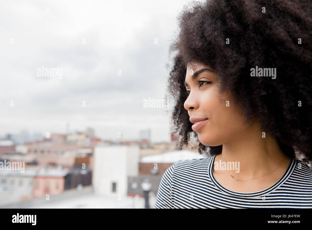 Afroamerikanische Frau lächelnd auf Dach Stockfoto