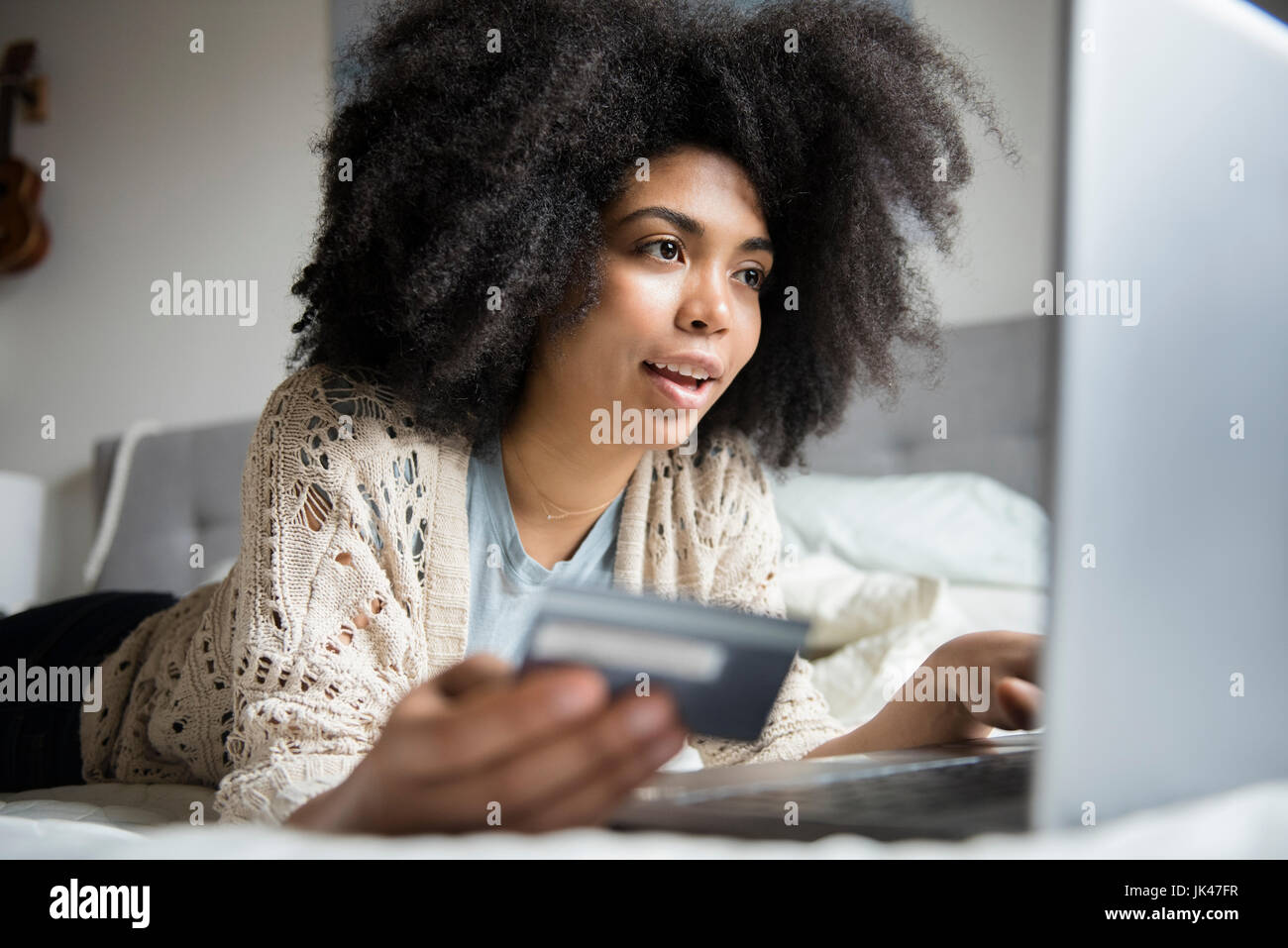 Afroamerikanische Frau im Bett mit Laptop Online-shopping Stockfoto