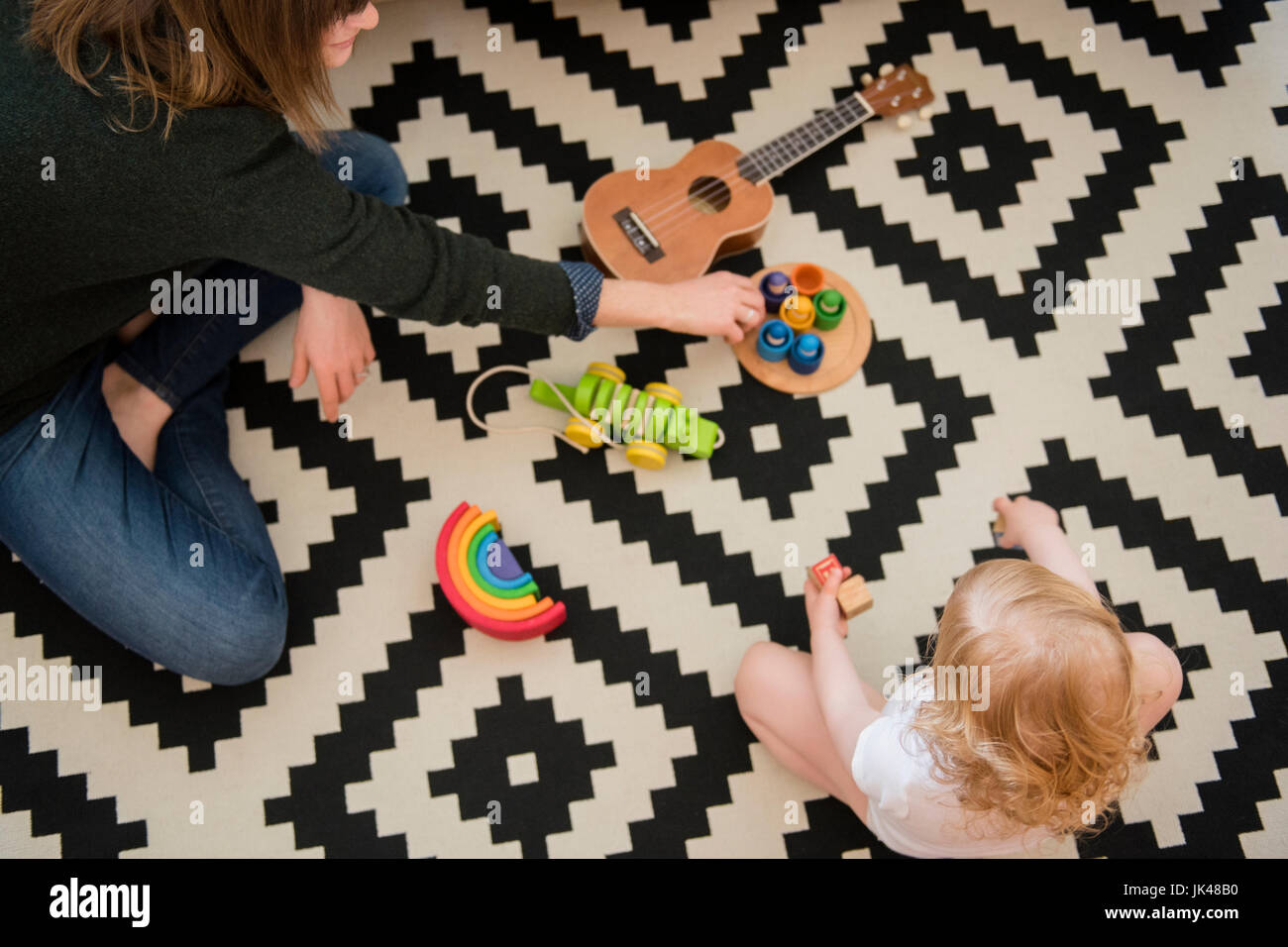 Kaukasische Mutter und Tochter sitzen am Boden spielen mit Spielzeug Stockfoto
